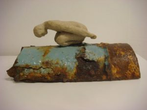 small sculpture of bending figure on pipe