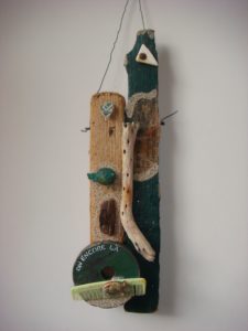 small sculpture of assembled found objects with text including driftwood